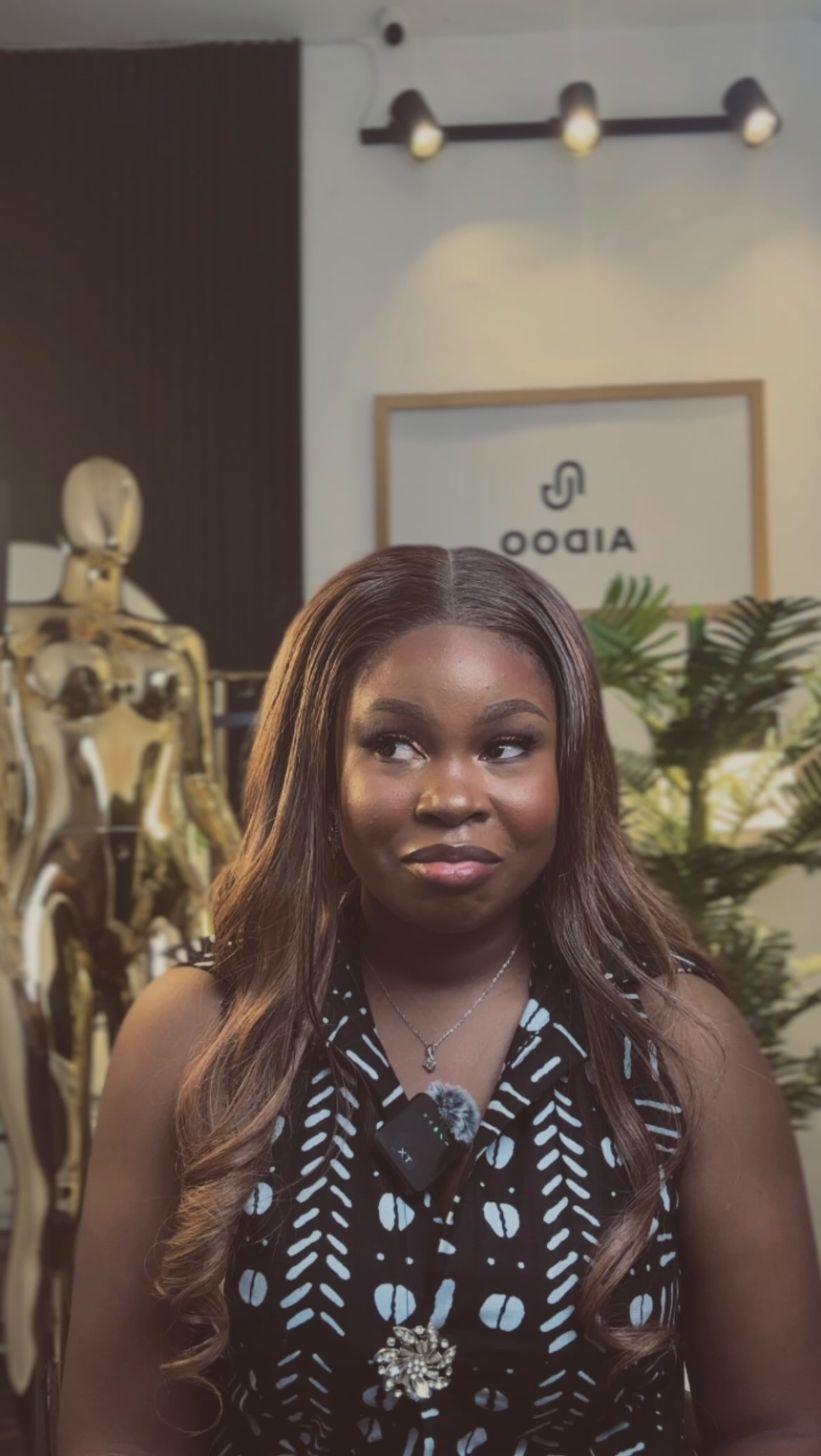 Aidoo's founder in the Lekki studio, in front of the gold-framed Aidoo sign