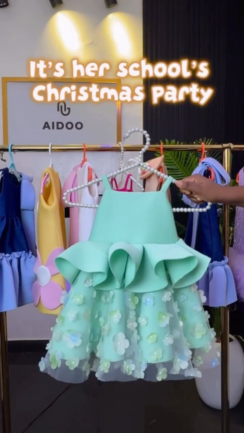 Mint peplum dress held up in front of the Aidoo studio rack